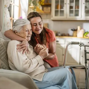 Caregiver supporting an older woman at home