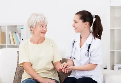 Care professional comforting an older woman