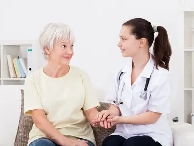 Care professional comforting an older woman